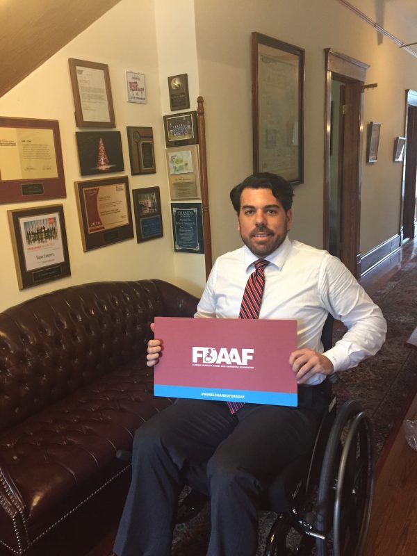 Dan Vasquez sitting in a wheelchair in his office